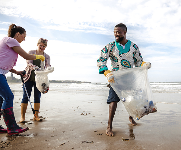 Agape image of volunteers clearing rubbish from a beach