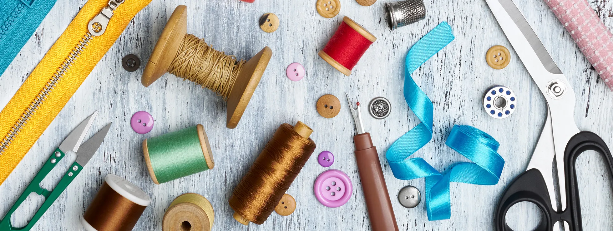 assortment of cotton reels, scissors, buttons, zips and other haberdashery, part of the Love Your Clothes visual identity